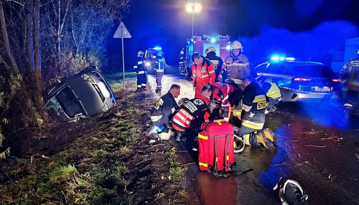 Dachowanie samochodu osobowego. Przydrożne drzewa zapobiegły stoczeniu się pojazdu do rzeki [ZDJĘCIA] - Zdjęcie główne