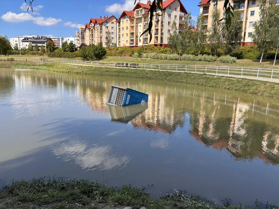 Przenośna toaleta w osiedlowym jeziorku