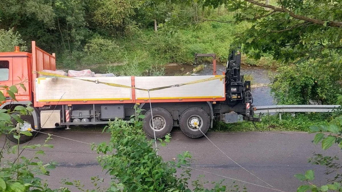 Samochód ciężarowy zawisł na barierach. Pojazd w każdej chwili mógł stoczyć się z nasypu - Zdjęcie główne