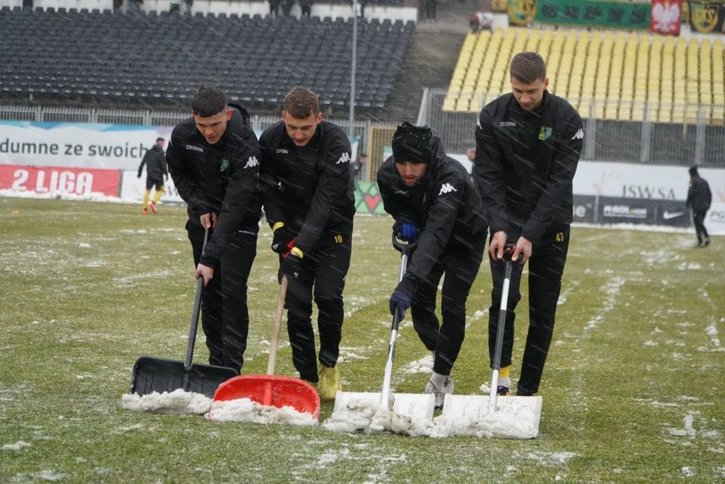 Atak zimy. Piłkarze i sztab trenerski Siarki Tarnobrzeg odśnieżają murawę obiektu w Jastrzębiu [ZDJĘCIA] - Zdjęcie główne