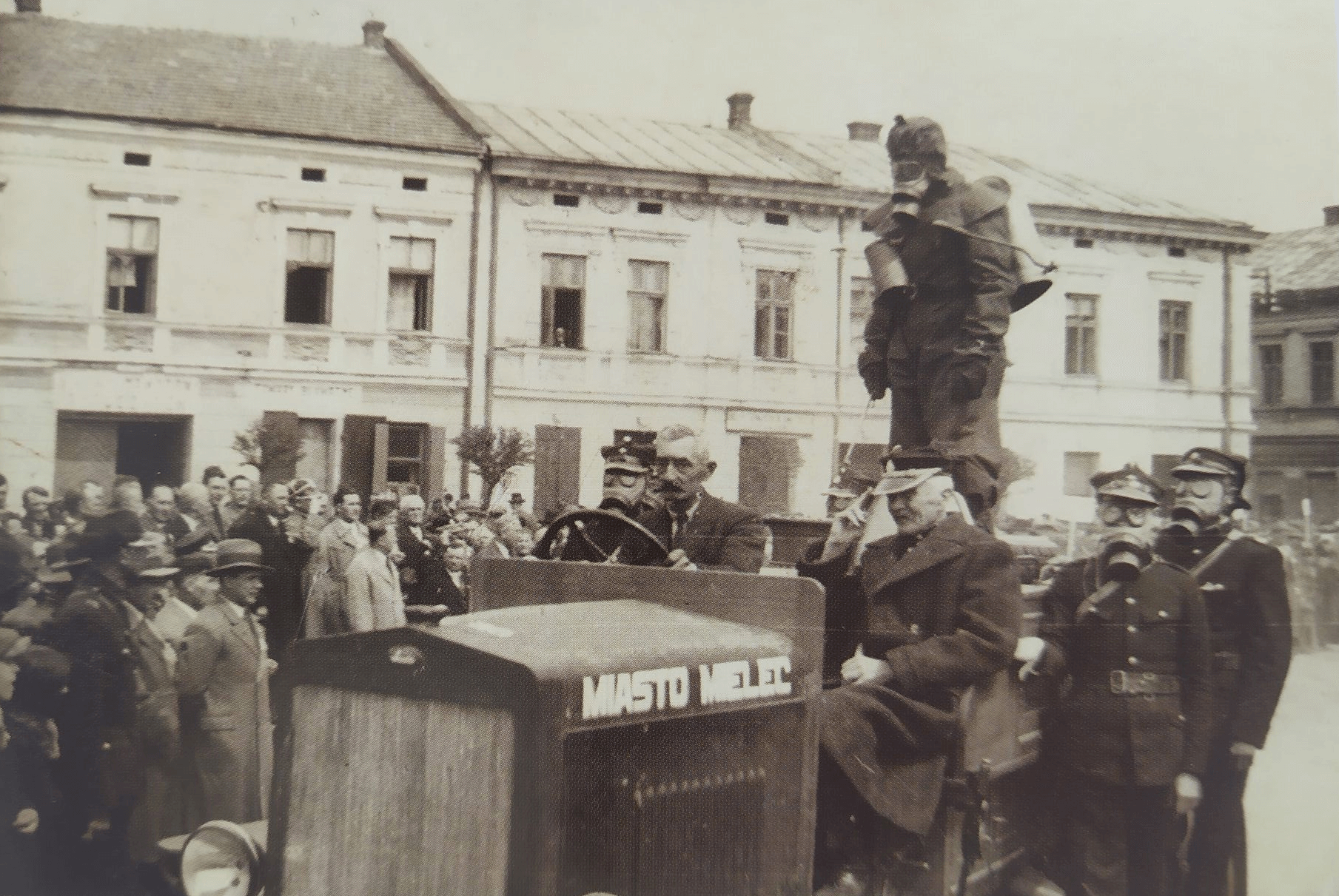 Pokazowy przejazd przez rynek strażaków w maskach gazowych (lata 30. XX w.)