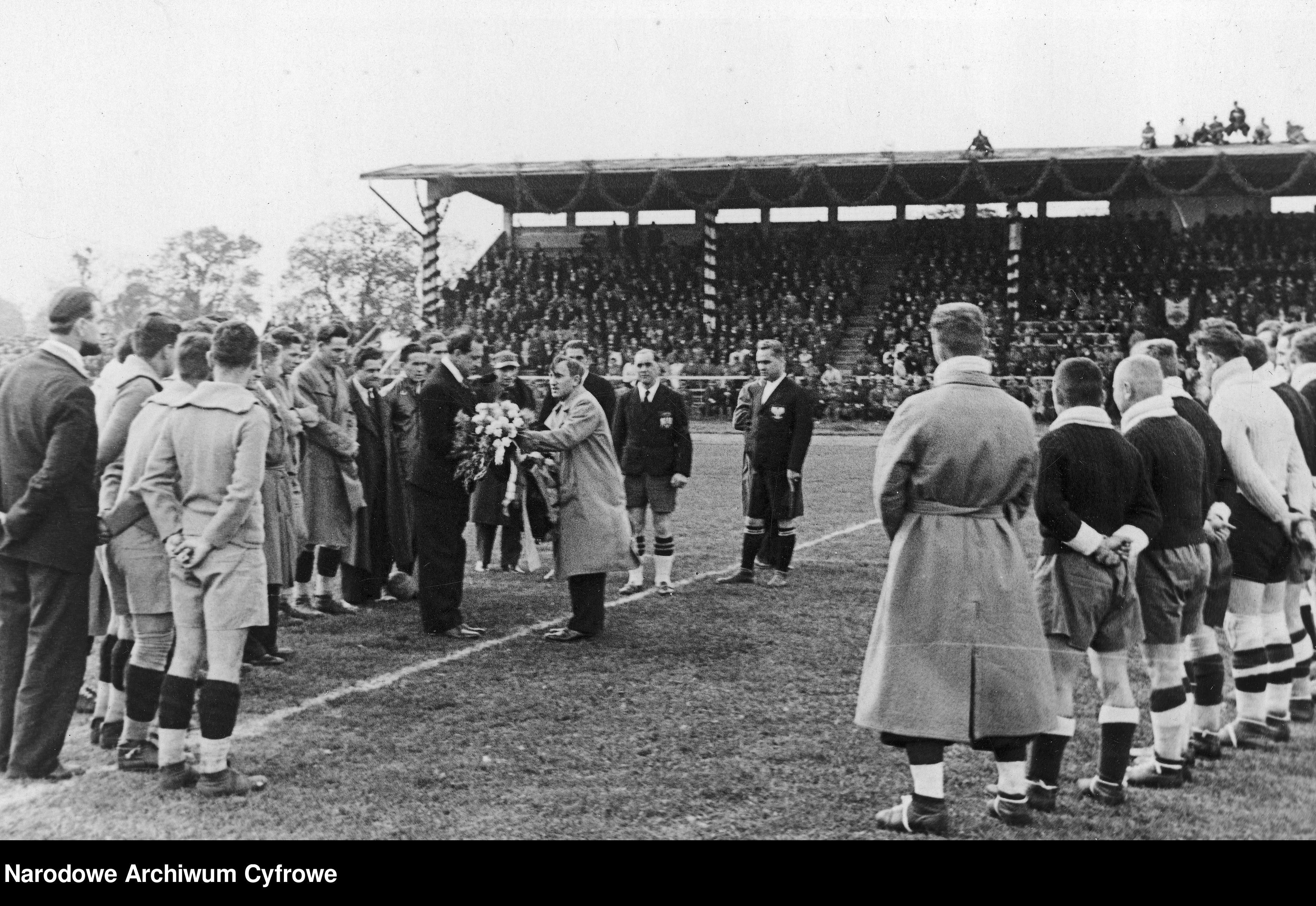 Trener polskiej reprezentacji Józef Kałuża (stoi pośrodku w jasnym płaszczu) wita rumuńskich piłkarzy. - 1934 rok: Polska - Rumunia we Lwowie.