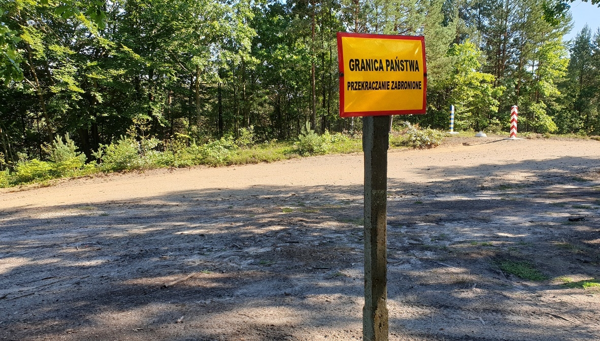 Mężczyzna z plecakiem przedzierając się przez las biegł w kierunku granicy - Zdjęcie główne